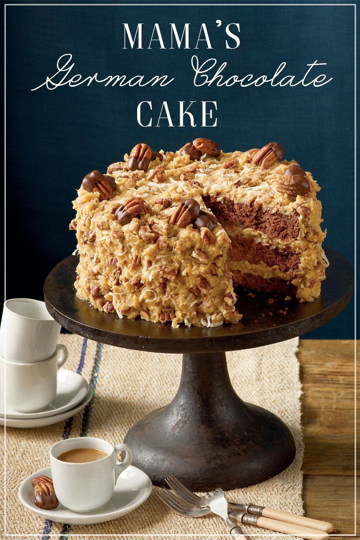 a cake with pecans on top is sitting on a plate next to a cup and saucer