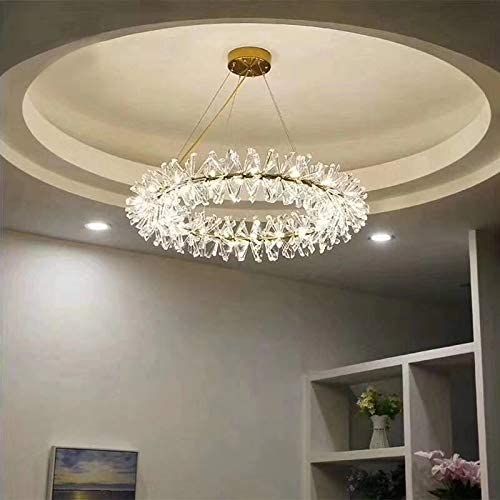 a chandelier hanging from the ceiling in a room with white walls and furniture