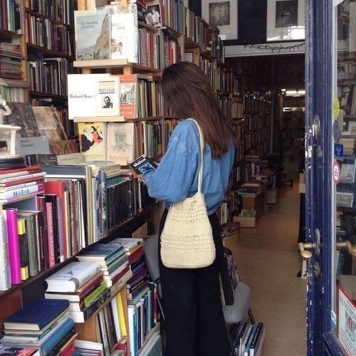 a woman looking at books in a book store