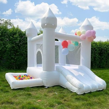 an inflatable bouncer and ball pit set up on the grass with balloons