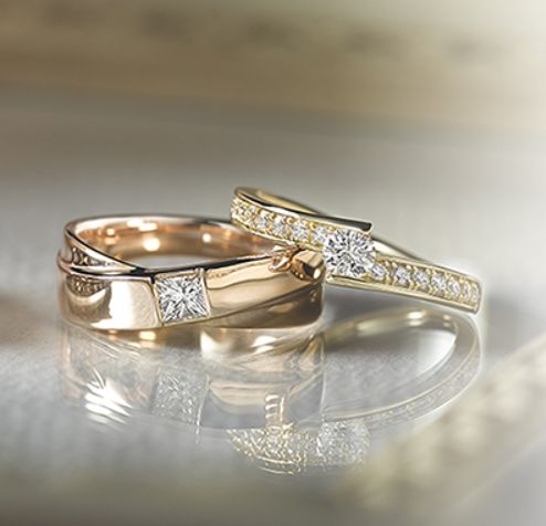 two gold wedding bands with diamonds on them