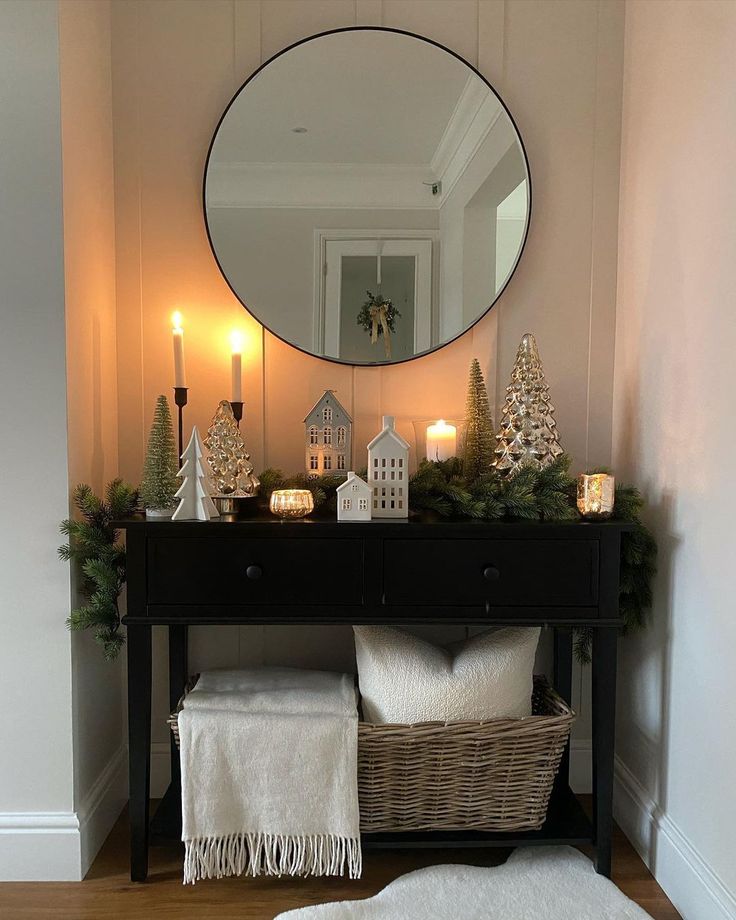 a table with candles and decorations on it in front of a round mirror over a black dresser