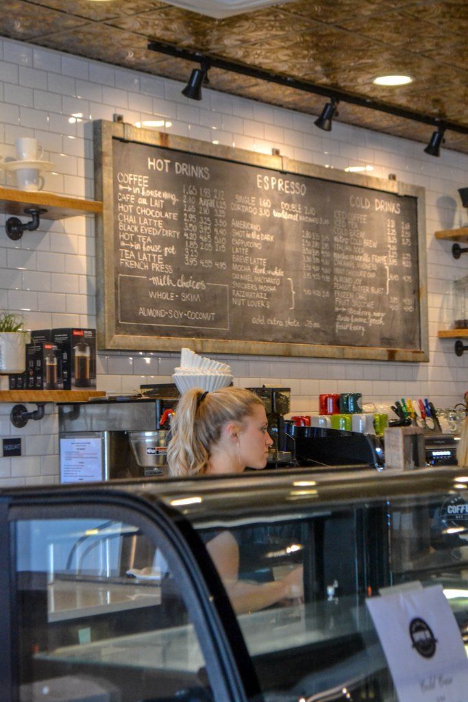 a woman sitting at a counter in front of a menu