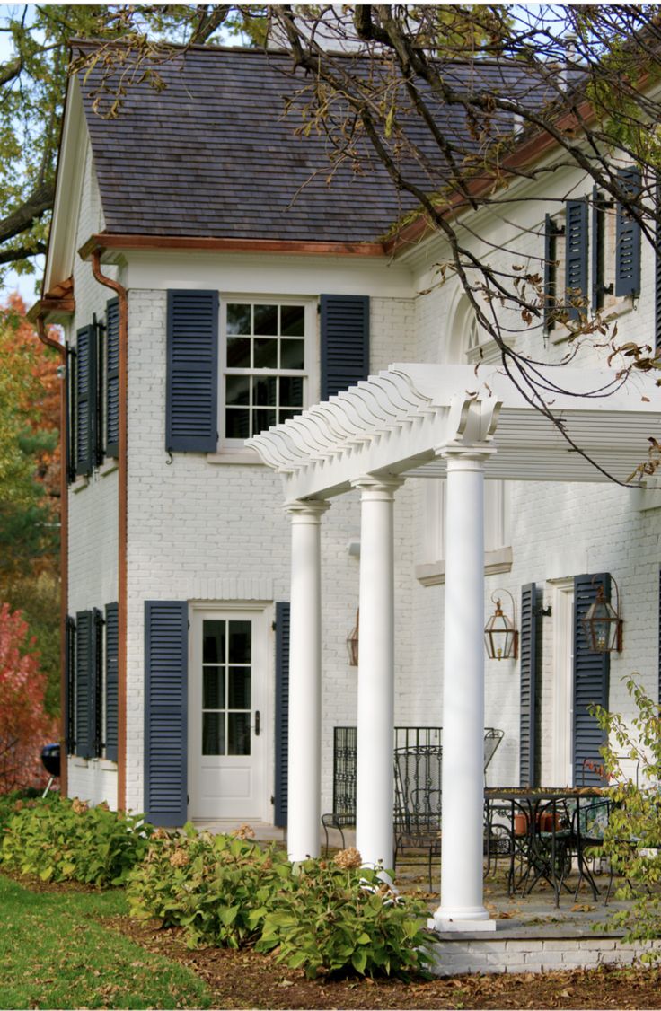 a white house with blue shutters and columns