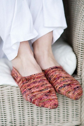 a person wearing slippers sitting in a wicker chair