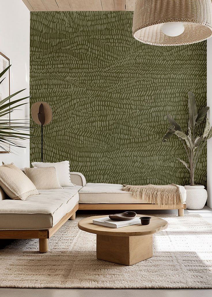 a living room filled with furniture next to a wall covered in green leafy paper