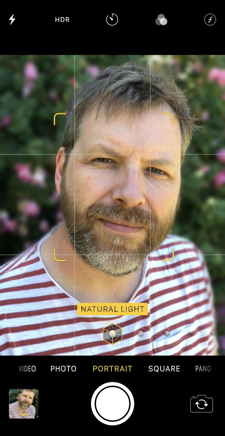 a man with a beard and striped shirt is shown in the screen above his face