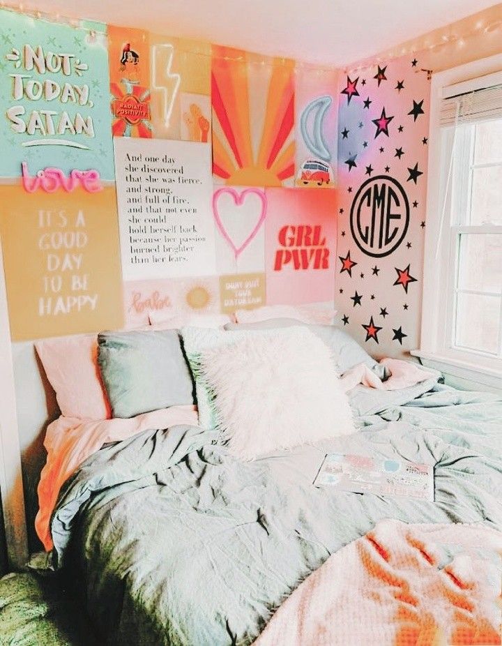 a bedroom decorated in pastel colors with posters on the wall and bed linens