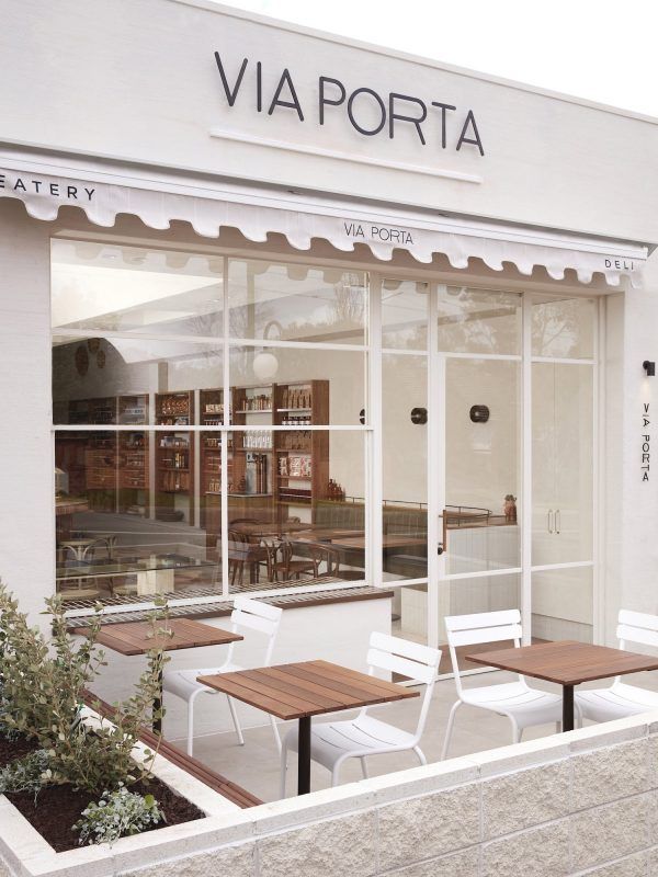 the outside of a restaurant with tables and chairs in front of it's windows