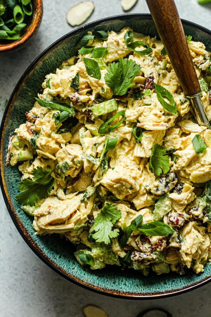 a bowl filled with chicken salad next to other bowls