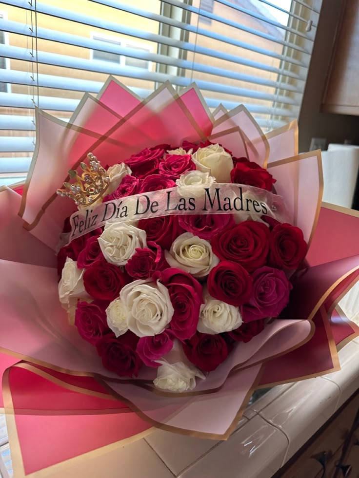 a bouquet of red and white roses with the words la dia de las madres on it