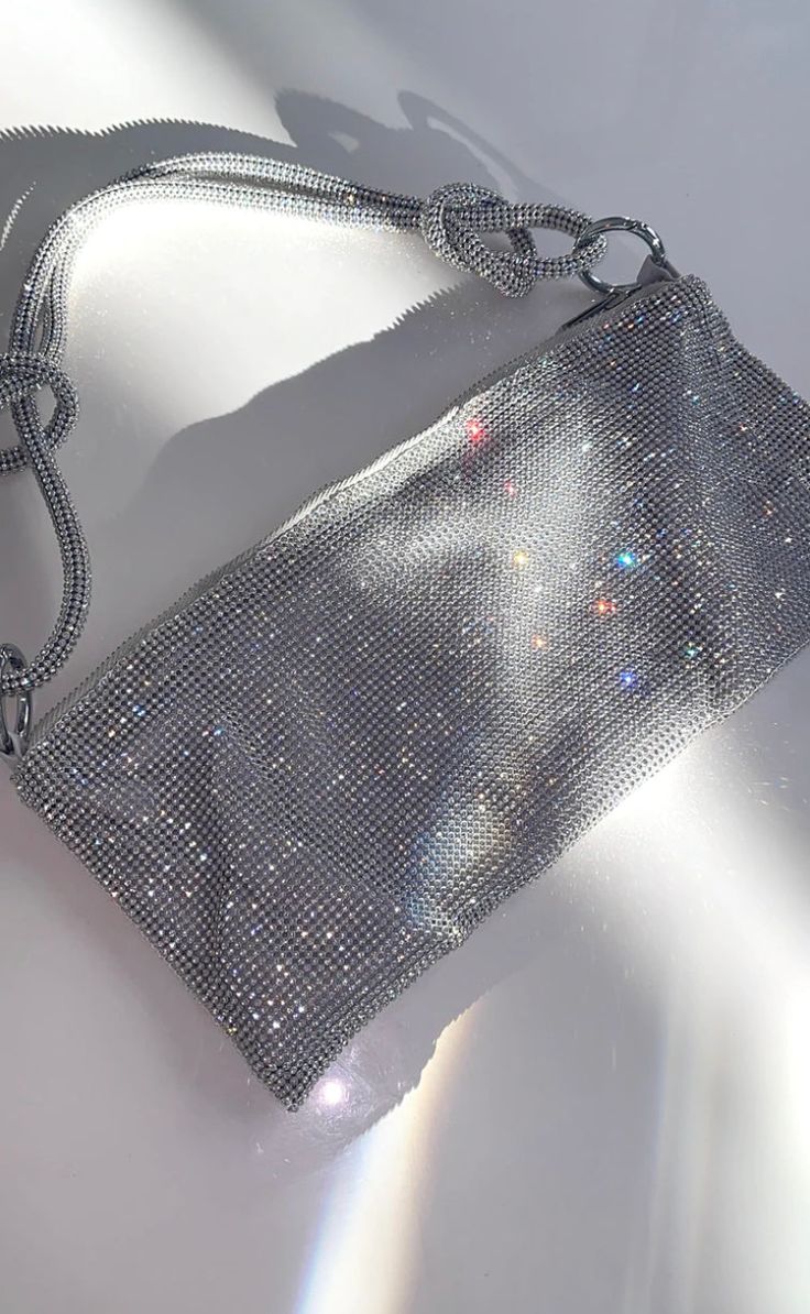 From our glitzy glam dreams! This little shoulder bag is the perfect eye-catching accessory! Perfect to wear as an evening bag for a wedding, or with your trendy night-out outfit! Also makes a great birthday or bride gift! PRODUCT INFO 12" length x 6" height x 10" drop from shoulder Silver hardware zipper closure Interior side compartment pocket Silver Formal Accessories, Sparkly Clutch Bag, Sparkly Bag Aesthetic, Cute Clutch Purse, Silver Clutch Purse Prom, Silver Prom Bag, Silver Bag Outfit, Bags For Prom, Sparkly Bags