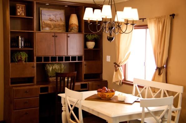 a dining room table and chairs in front of a bookcase