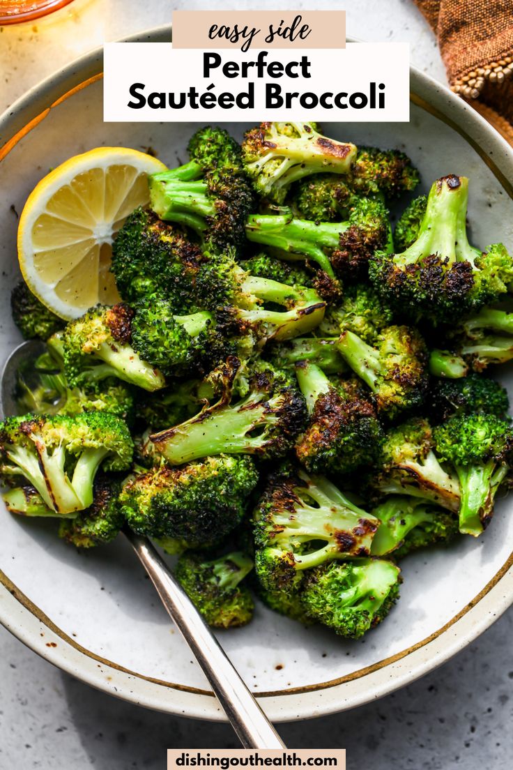 a bowl filled with cooked broccoli and lemon wedges