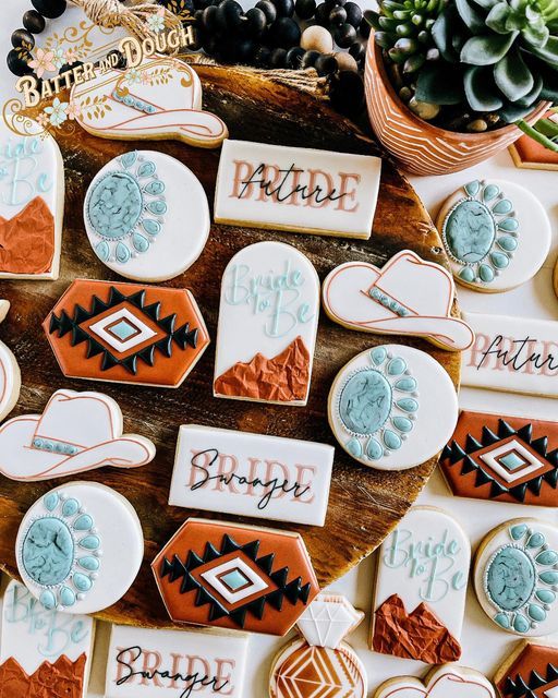 decorated cookies are arranged on a table with succulents and other items in the background