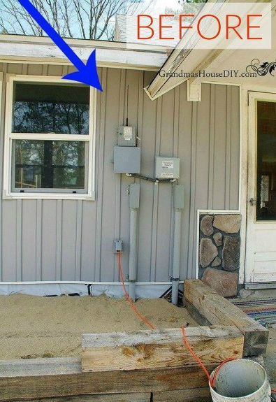 a house that has some sand in front of it and an air conditioner on the outside