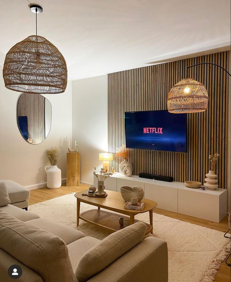 a living room filled with furniture and a flat screen tv mounted on the wall above it