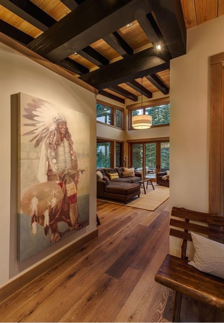 a living room filled with furniture and a painting on the wall next to a window