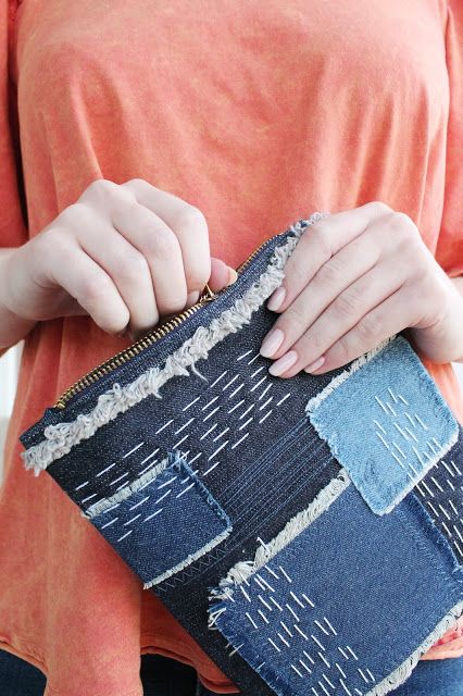 a woman is holding an old pair of jeans in her hand and the bottom half of her purse