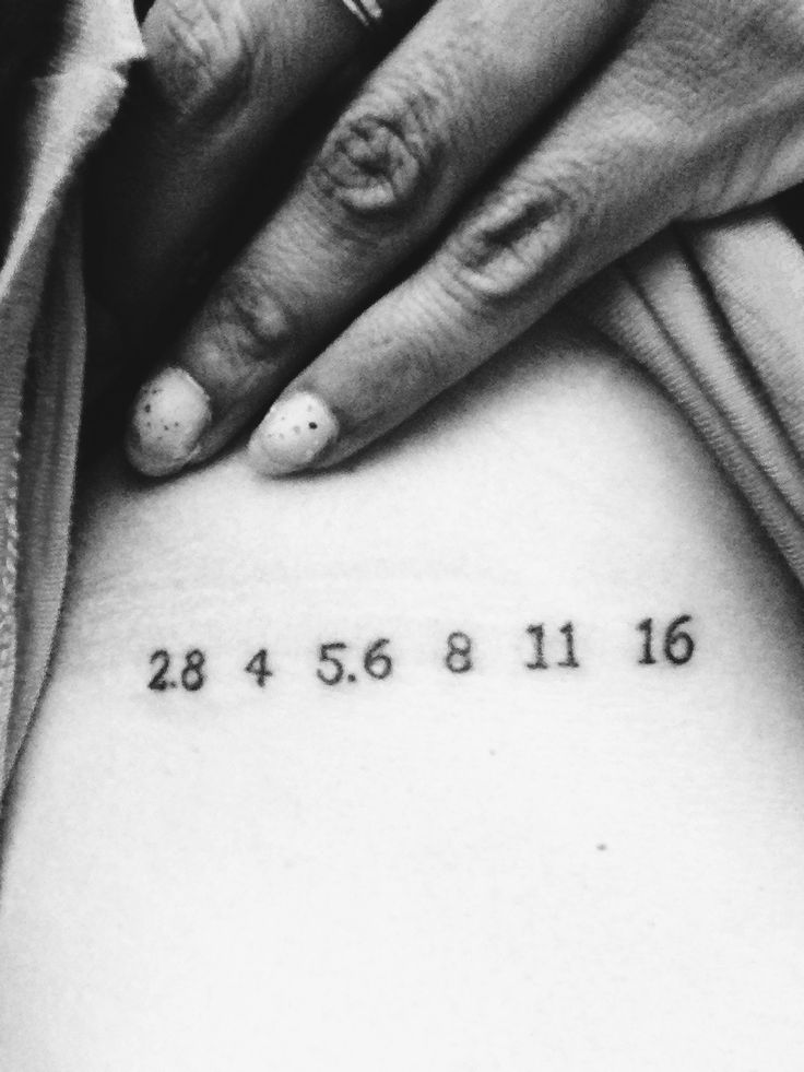 a woman's stomach with the date tattooed on her lower back, in black and white