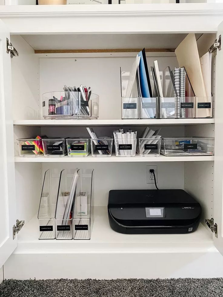 a white book shelf filled with lots of books and office supplies on top of a carpeted floor