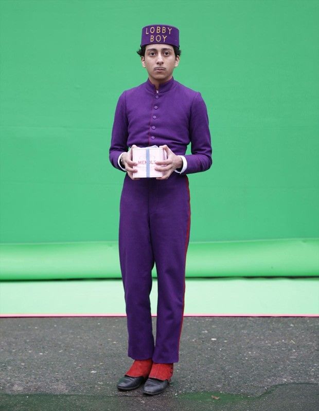 a man dressed in purple is holding a box