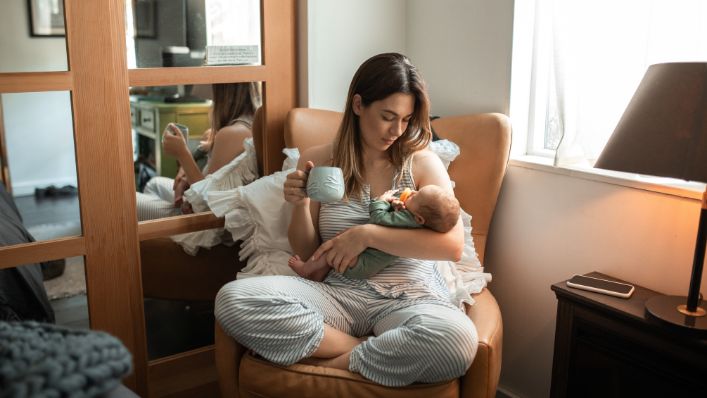 a woman sitting in a chair holding a baby