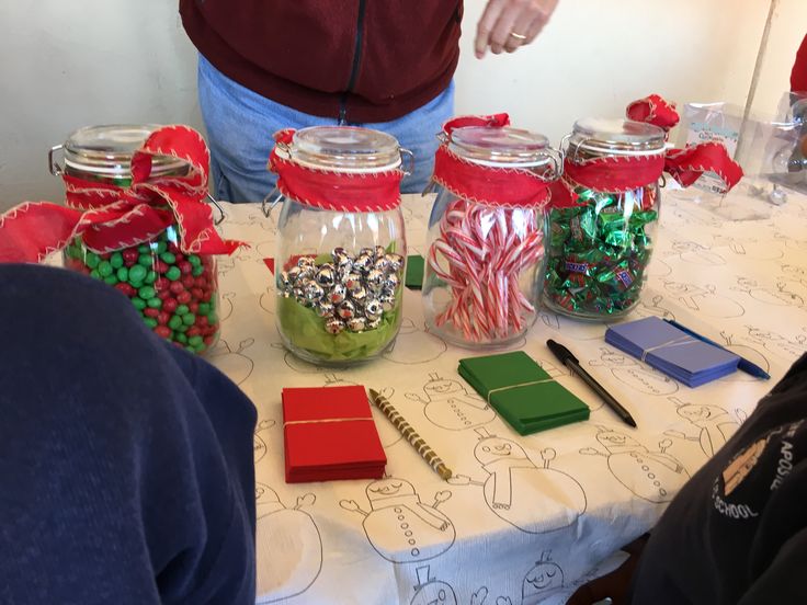 a table topped with jars filled with candy canes and candies on top of it