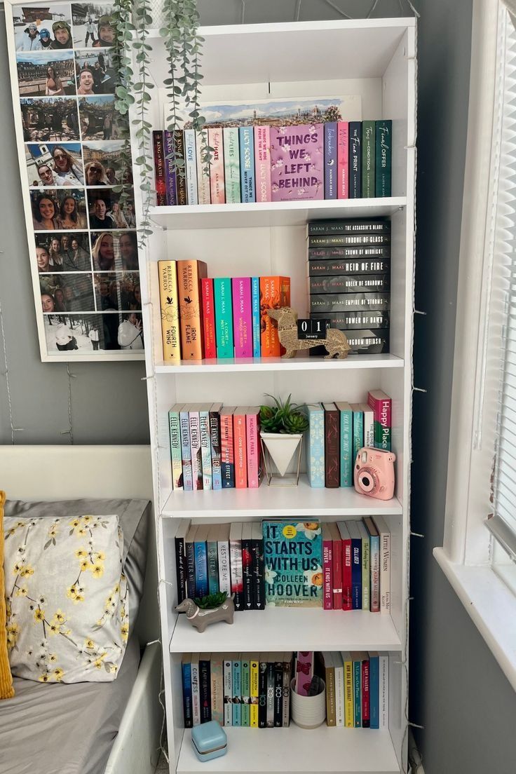 a bookshelf filled with lots of books next to a white window sill