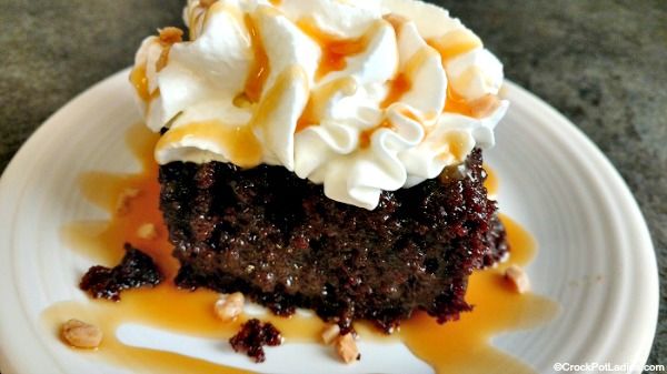 a piece of chocolate cake with whipped cream and walnuts on top, sitting on a white plate