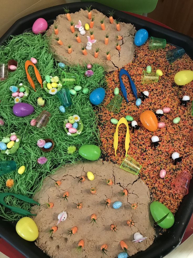 a tray filled with lots of fake grass and candy