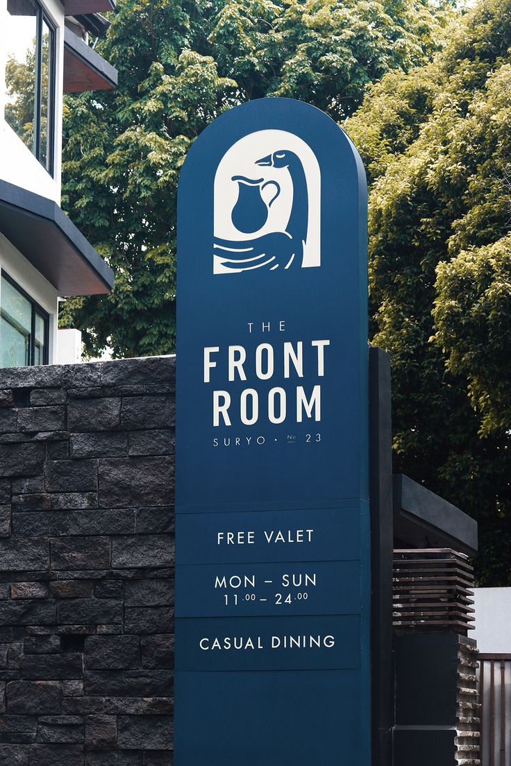 a sign for the front room with trees in the background