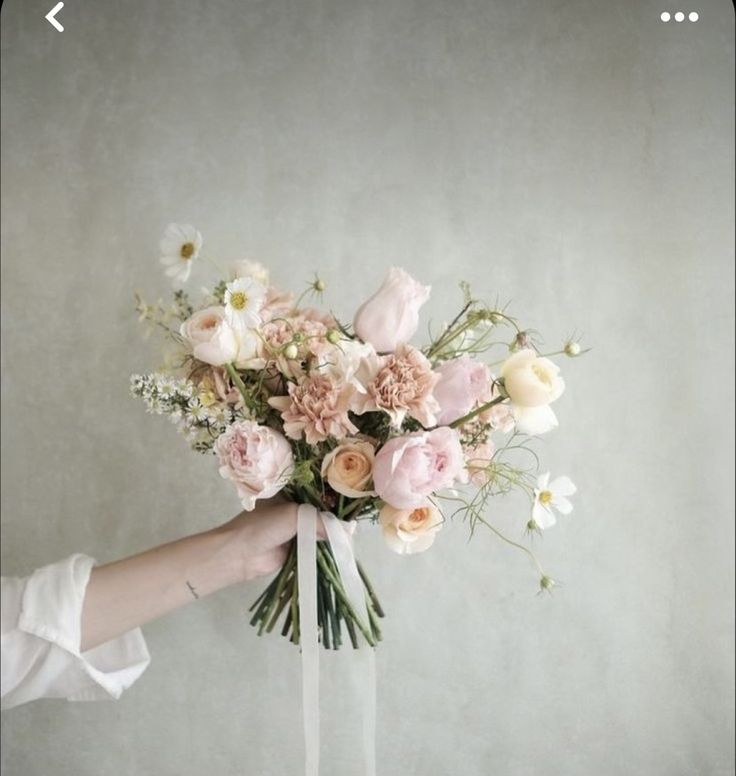 a person holding a bouquet of flowers in their hand