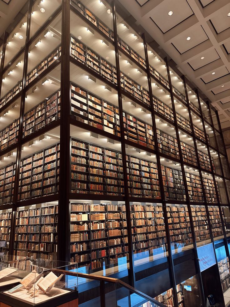 a large library filled with lots of books on top of metal shelves next to a staircase