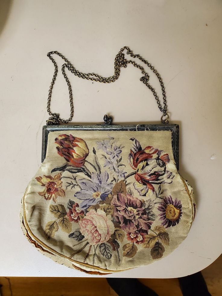 This lovely antique purse has a lovely open field with large floral print, contrary to most of the French handmade purses made during the early 20th century which showcase a smaller floral design. The bag also displays a dual shoulder strap which is also unique to Antique French Purses. Unfortunately through the years the outside rim of the bag deteriorated. The bag can be fixed up and made to look back to its original authentic design for a minimal amount of money. Make this unique piece yours today! Antique Purse, Peachy Den, Designer Handbag Brands, French Luxury Brands, Large Floral Print, Goyard Bag, Popular Handbags, Timeless Chic, Gardening Outfit