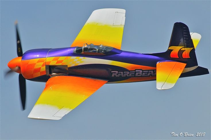 an orange and blue plane flying in the sky