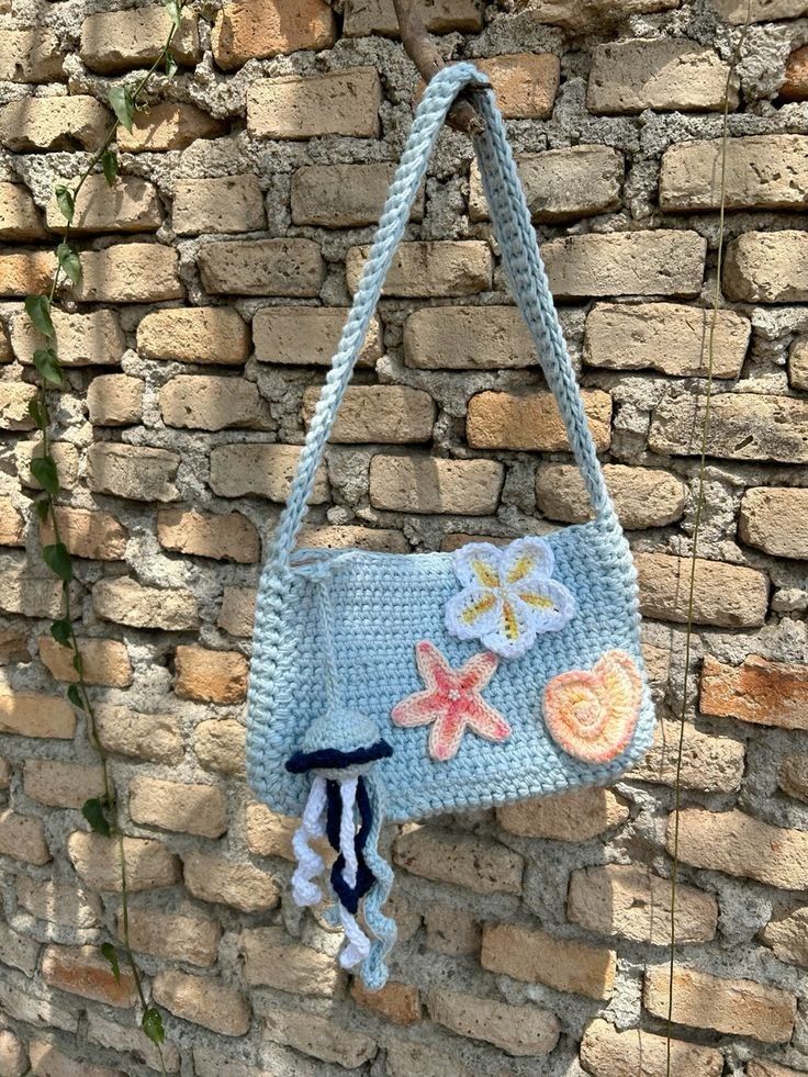 a crocheted purse hanging on a brick wall