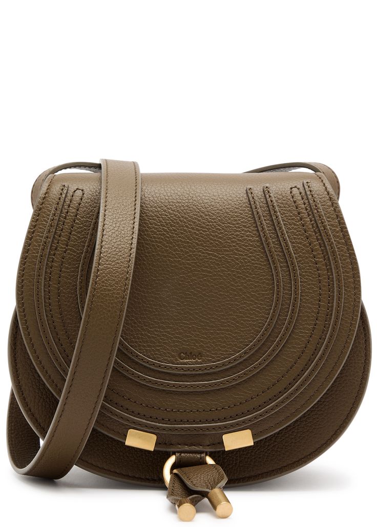 Long Description#Style Notes#This small version of Chloé’s Marcie bag may be compact, but it still incorporates all the signature features. Crafted from grained leather to a rounded silhouette, this everyday style is adorned with curved saddle stitches that tap into the label’s 70s bohemian spirit.#Info & Care#
Chloé grained leather saddle bag
Adjustable shoulder strap, debossed designer stamp, appliquéd and stitched details at front flap, concealed slit pocket at flap front, internal patch pocket, fully lined
Ring fastening at flap front
#Size & Fit#
Width: 7.5 inches/ 19cm
Height: 7 inches/ 17.5cm
Depth: 4 inches/ 10cm
Min. shoulder strap drop: 20 inches/ 51cm
Max. shoulder strap drop: 24 inches/ 61cm 70s Bohemian, Leather Saddle Bags, Womens Khakis, Dark Khaki, Saddle Bag, Everyday Style, Saddle Bags, Patch Pocket, Everyday Fashion