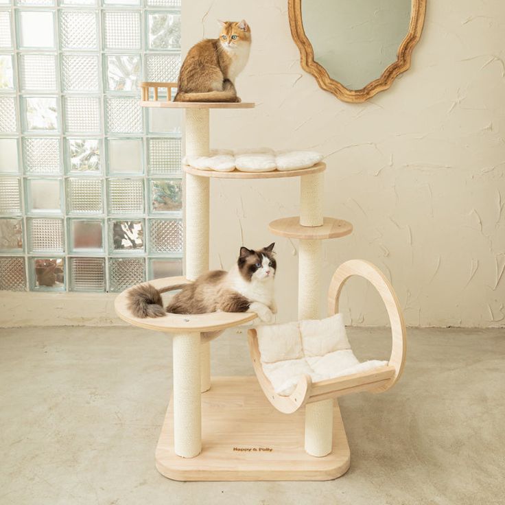 a cat sitting on top of a scratching tower in front of a wall with a mirror