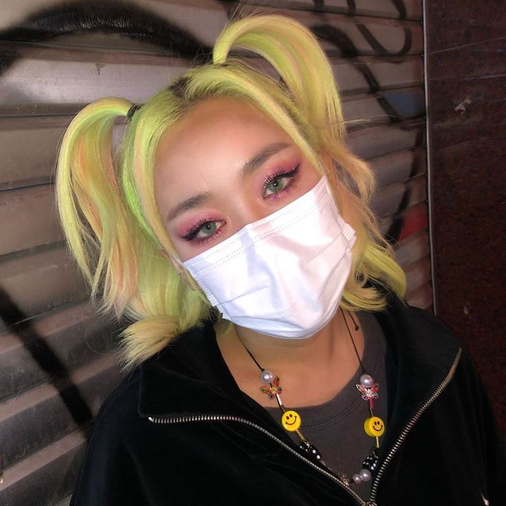 a woman with blonde hair wearing a face mask