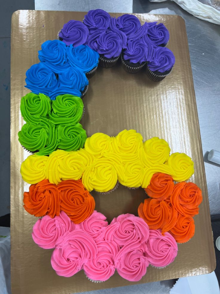 cupcakes are arranged in the shape of an o on top of a cardboard box