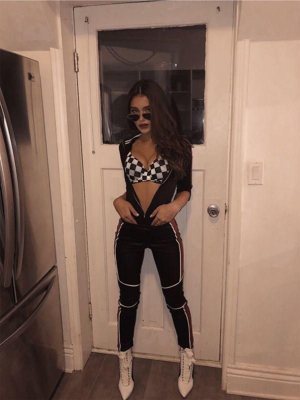 a woman standing in front of a door wearing black and white checkerboard outfit