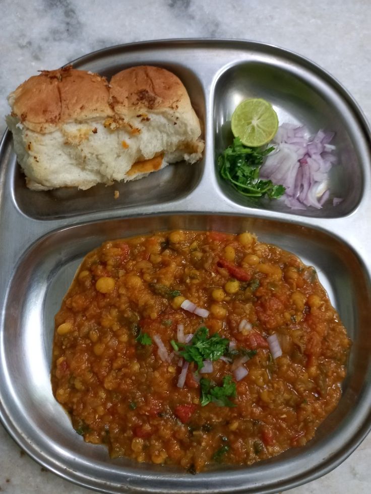 a metal tray topped with food next to a sandwich