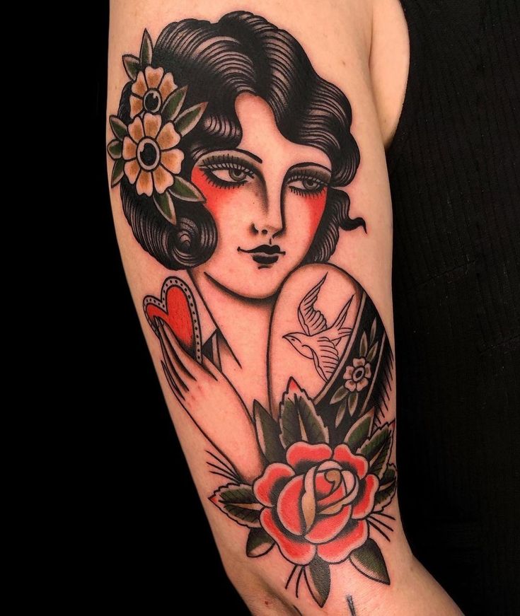 a woman's arm with tattoos and flowers on it