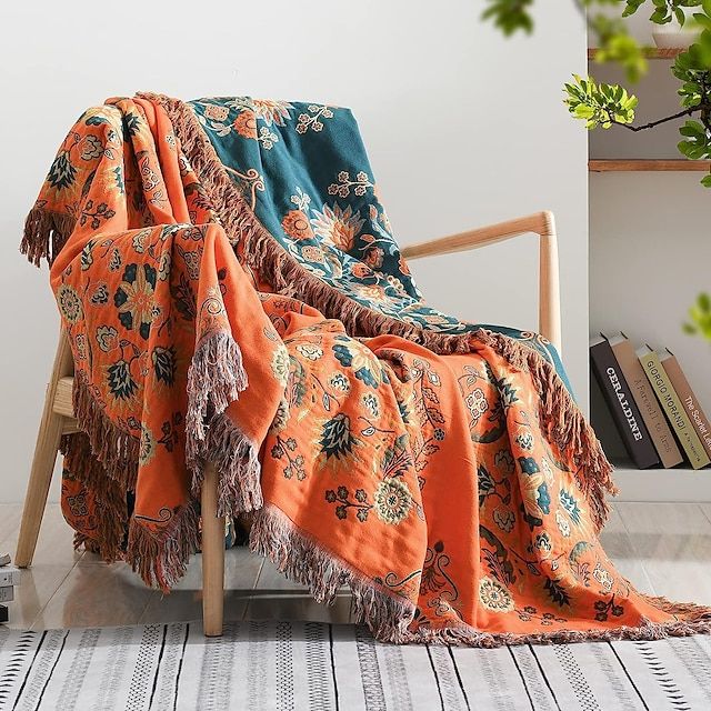 an orange and blue blanket sitting on top of a wooden chair