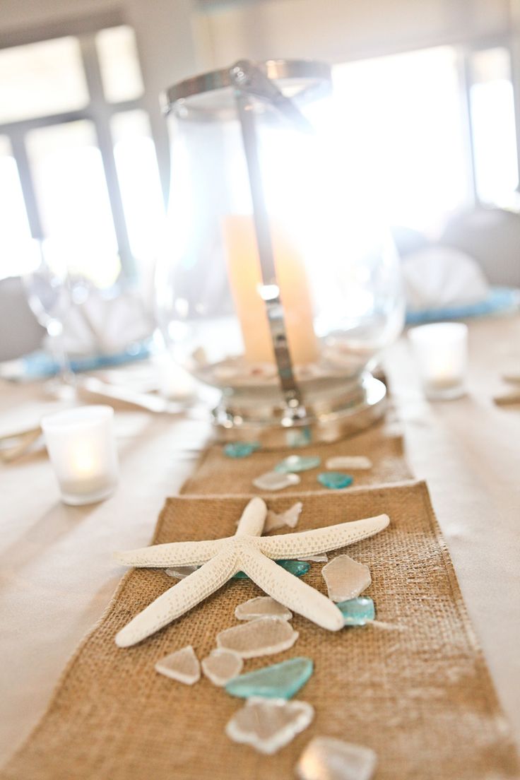 the table is set with starfish and seashells on burlap linen