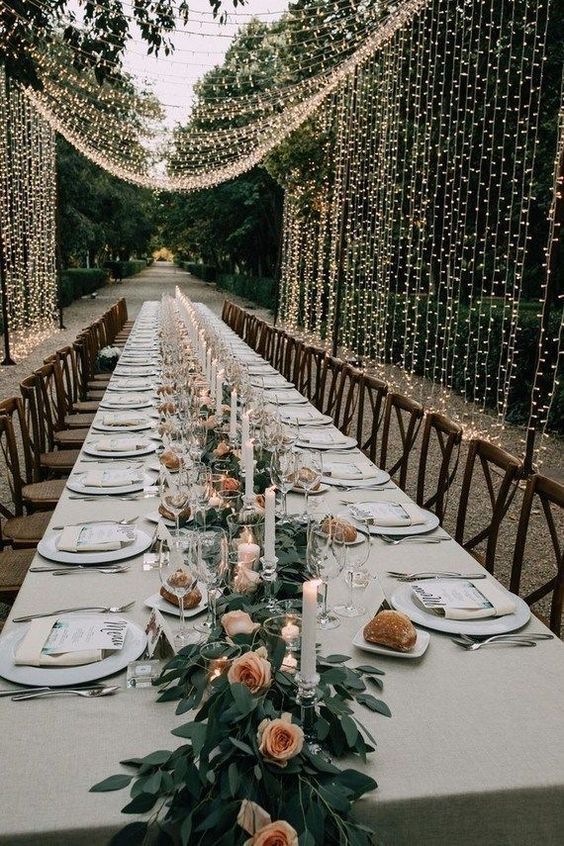 a long table is set with plates and candles