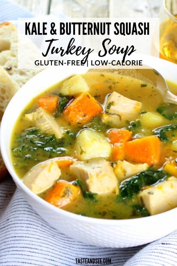 a white bowl filled with turkey soup next to bread