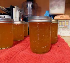 three jars filled with liquid sitting on top of a red towel