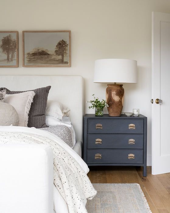 a bedroom with a bed, nightstand and pictures on the wall